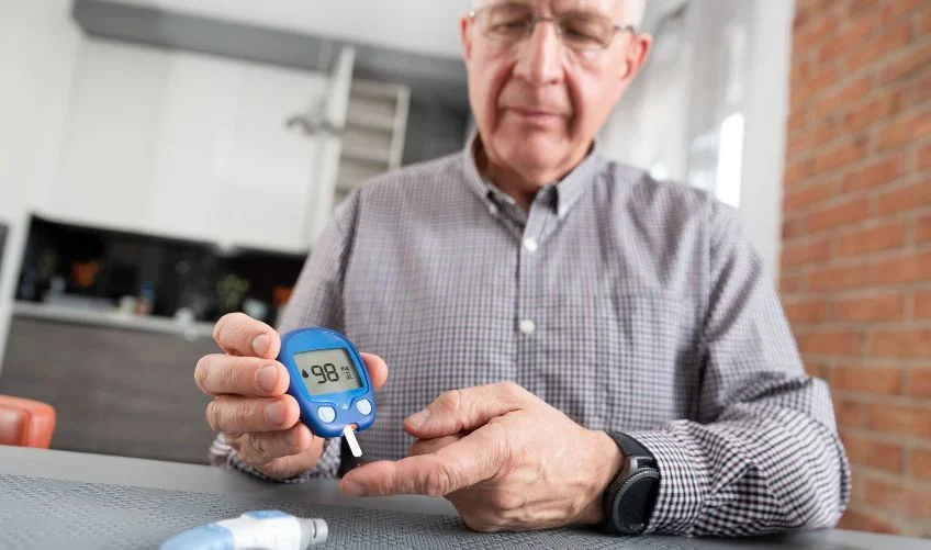 Elderly man checking blood sugar level