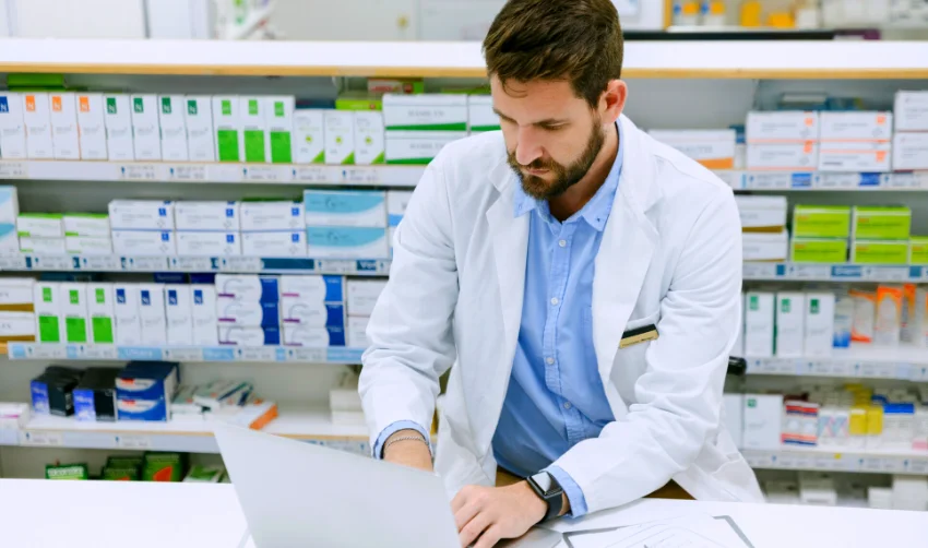 Photo of a pharmacist using a laptop while working