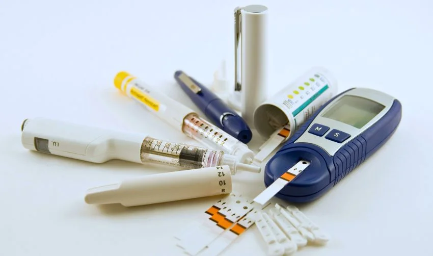 Diabetic medication supplies laid out on white background