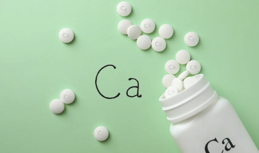 Flat Lay Composition with Calcium Supplement Pills on Light Green Background